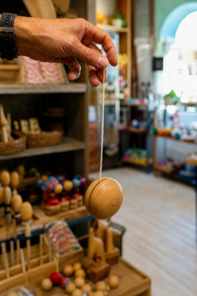 Profil d’un yo-yo en bois sous une main immobile