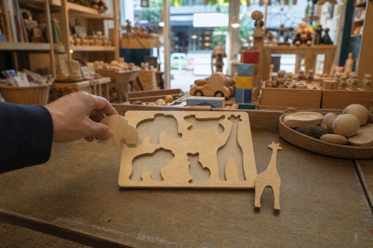 Animal puzzle in front of shelves of wooden toys