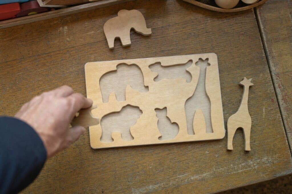 Holzpuzzle mit Tierformen auf einem abgenutzten Tisch