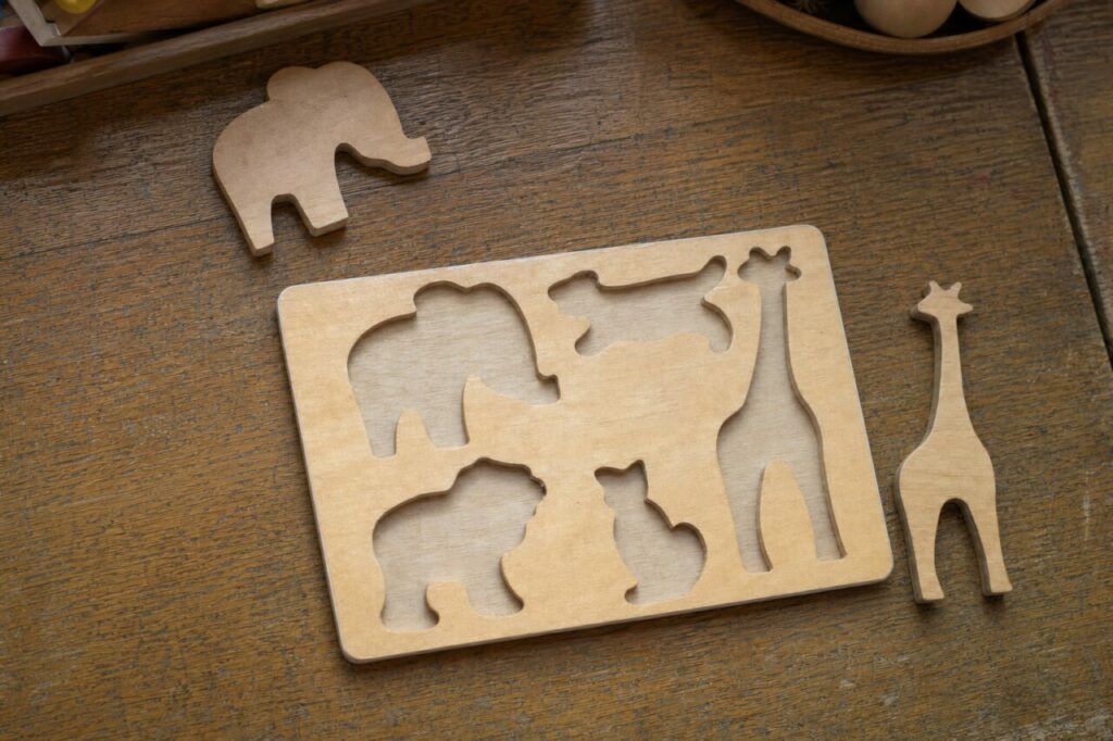 Holzpuzzle von oben mit Elefant und Giraffe daneben