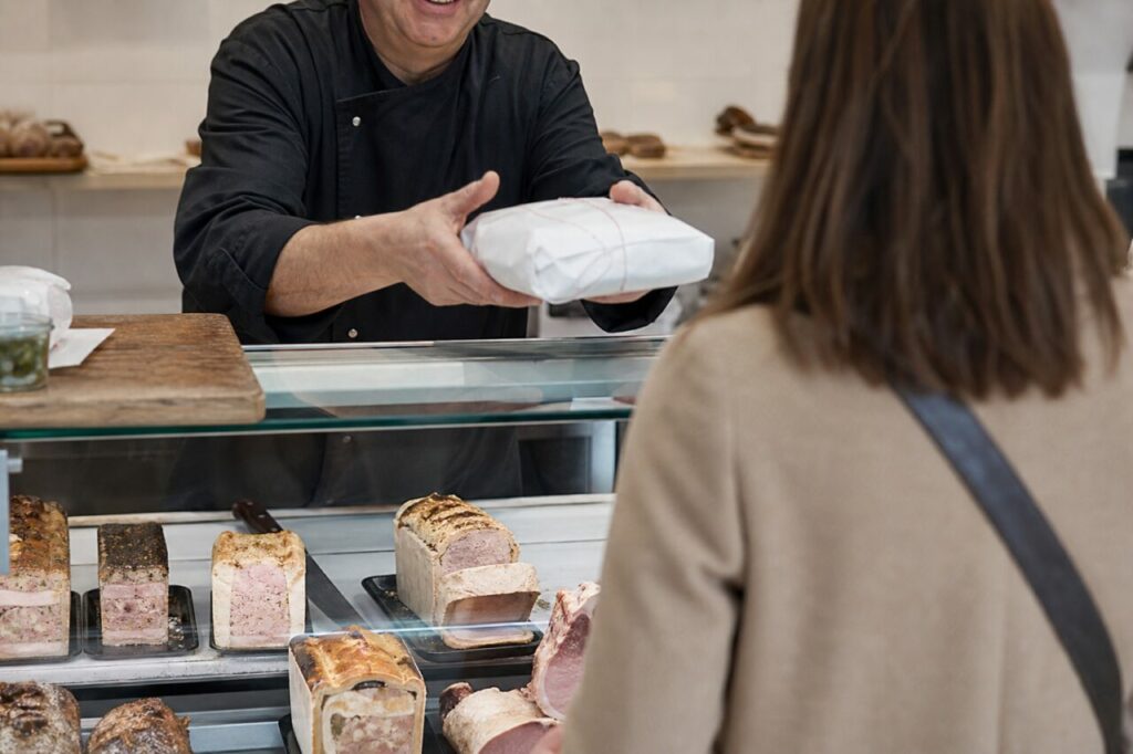 Remise d’un paquet au comptoir d’une boucherie