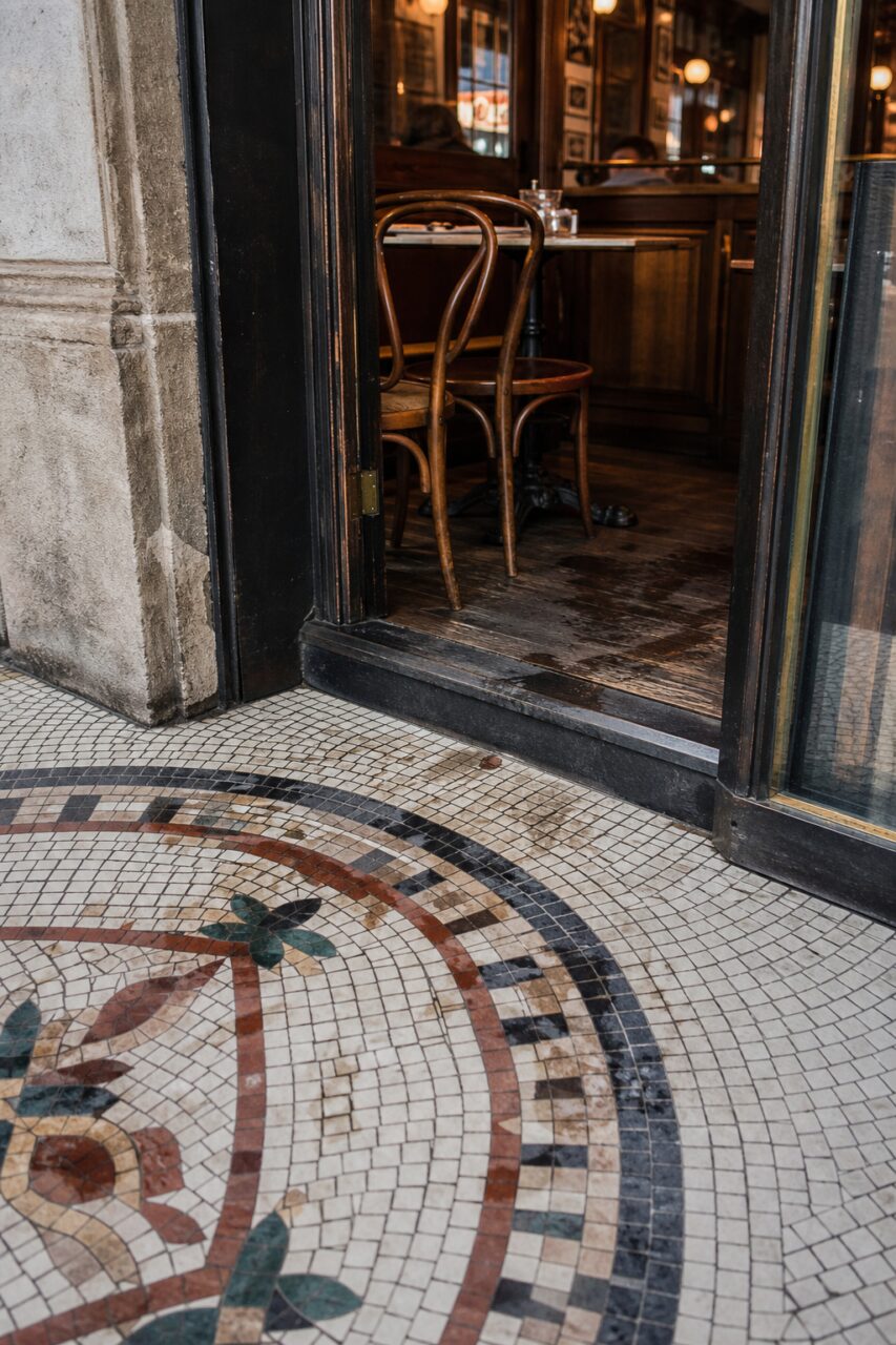 Colourful mosaic rosette in front of a brasserie doorway