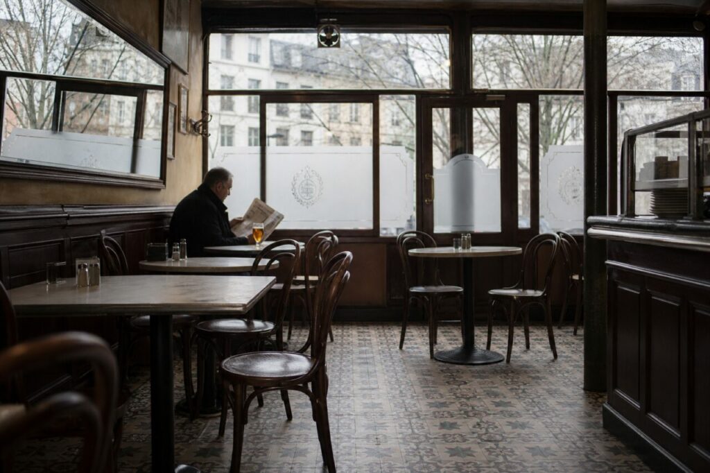 Café room with patterned tiles and a reader by the window