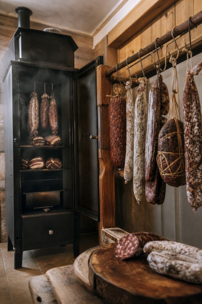 Saucissons et charcuteries suspendus dans un fumoir