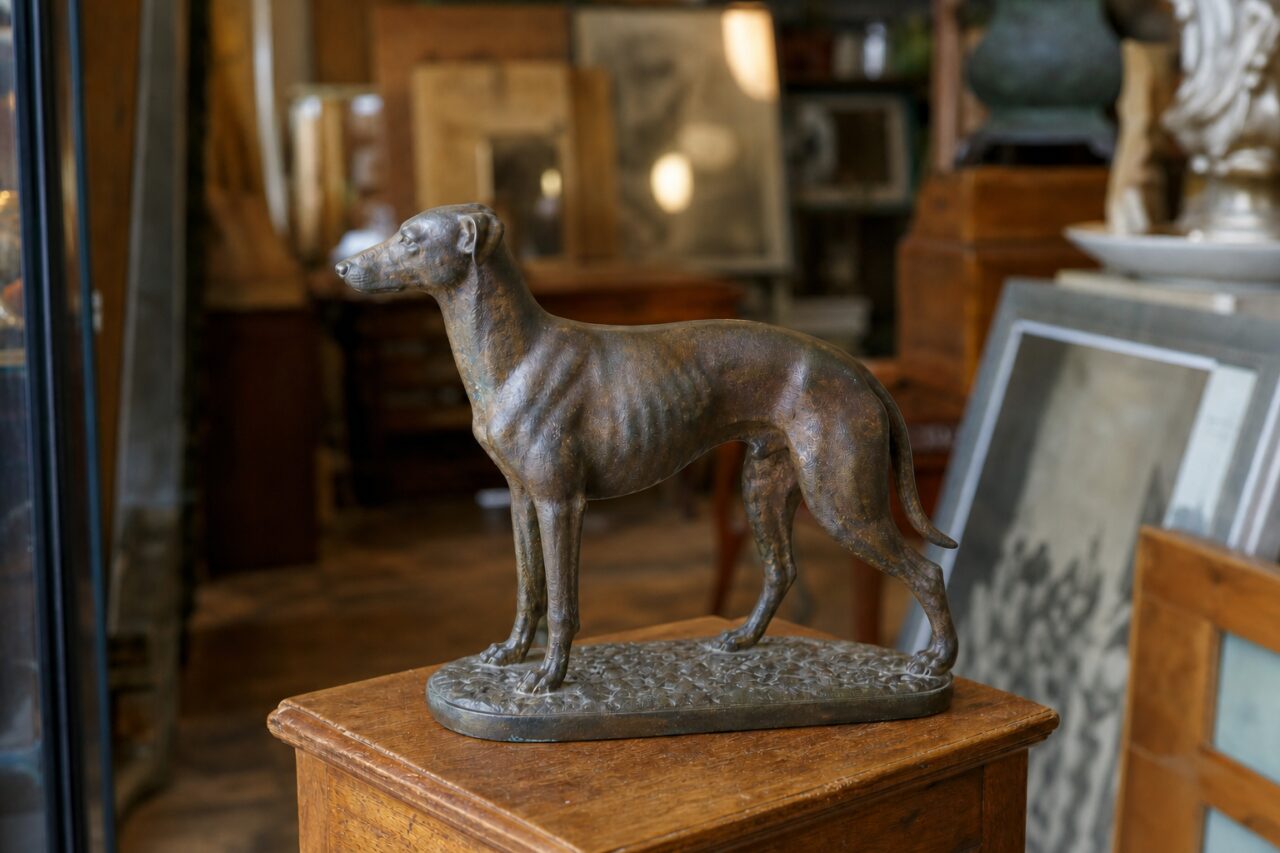 Sculpture de chien en bronze vue en légère plongée sur un meuble de brocante