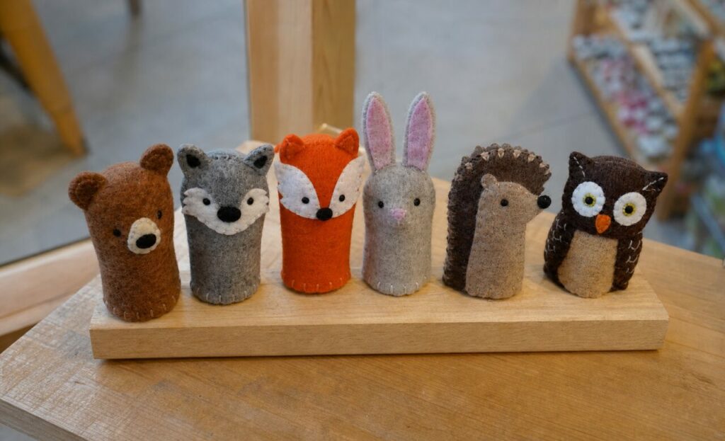 Six visages cousus réunis sur le bloc de bois de la boutique
