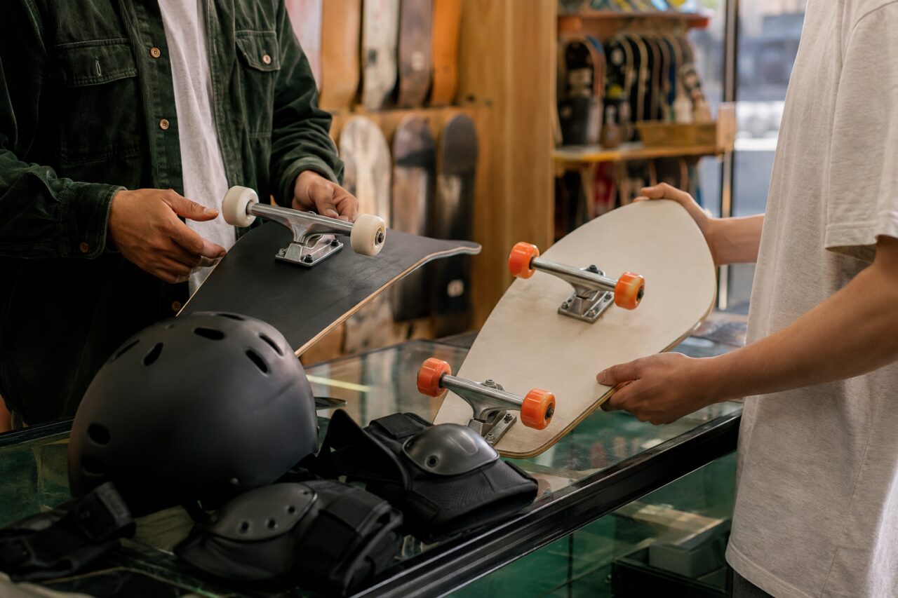Dos longboards sostenidos sobre una vitrina con casco y protecciones