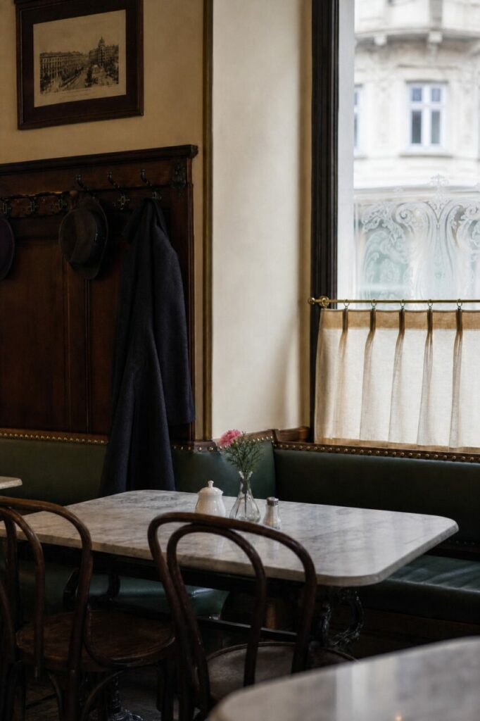 Lichte tafel en bruine stoelen voor een bank onder het raam