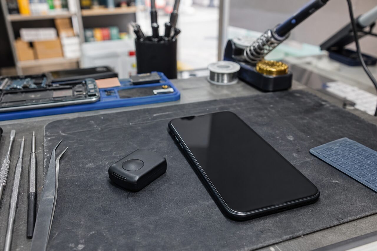 Black phone and small case on a workbench mat