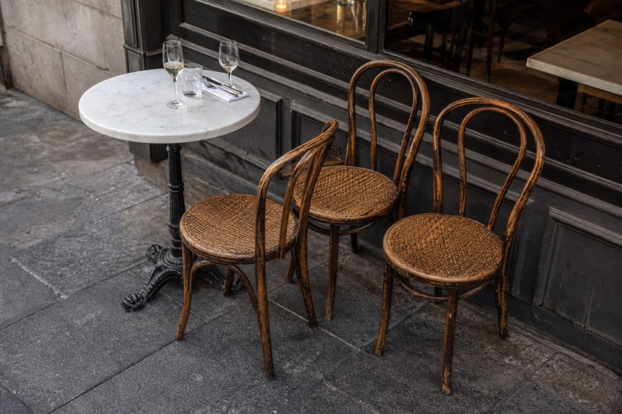 Esplanada de brasserie com mesa de mármore e cadeiras de madeira curvada