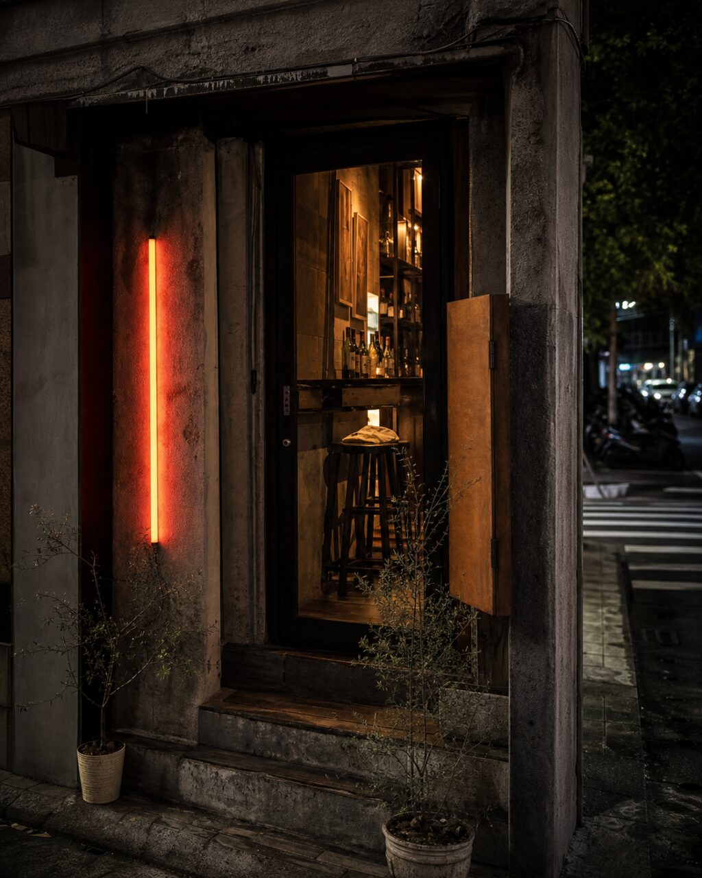 Three steps leading to a lit glazed door