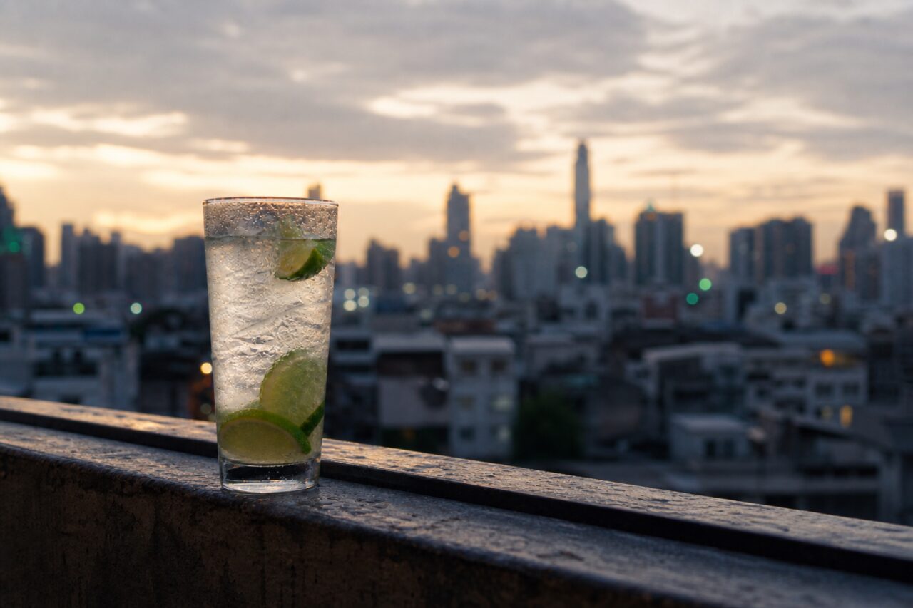 Verre de boisson citronnée devant une ligne d’horizon au coucher du jour