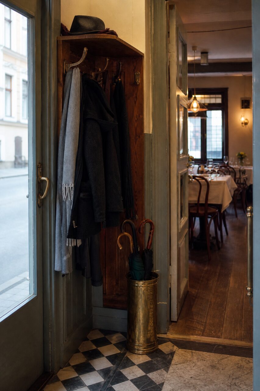 Vestiaire, parapluies et salle aux tables dressées