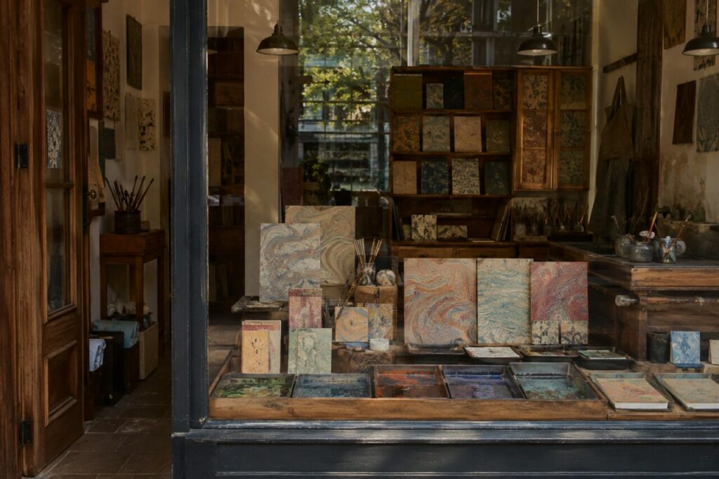 Vitrine d’atelier de papier marbré avec feuilles colorées, pinceaux et carnets