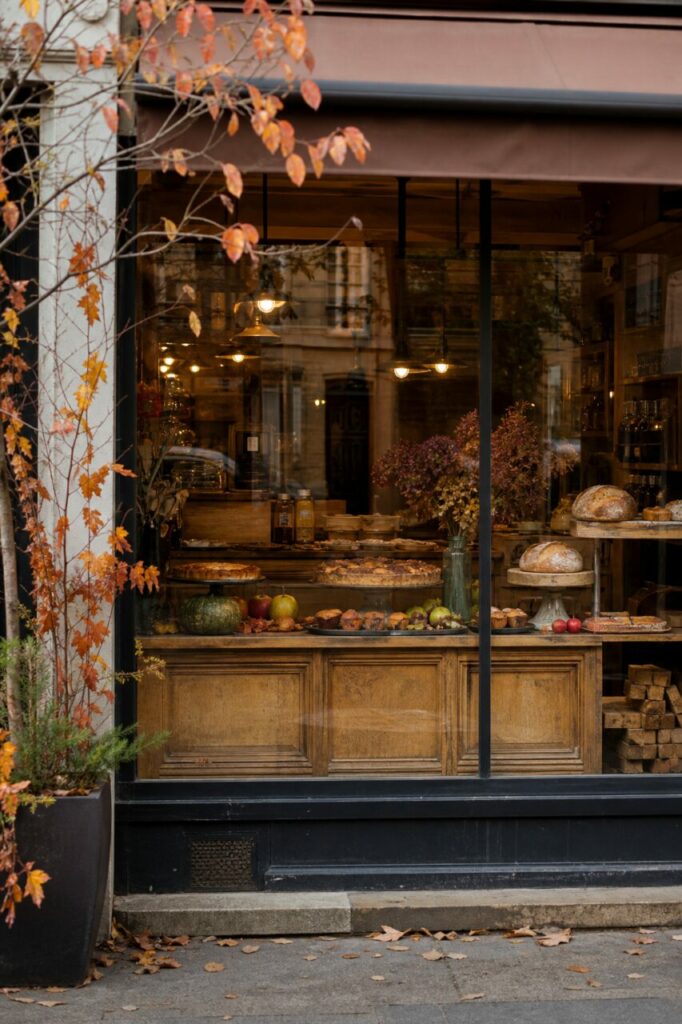 Vitrine aux feuilles orange avec tartes, pains et bouquets séchés