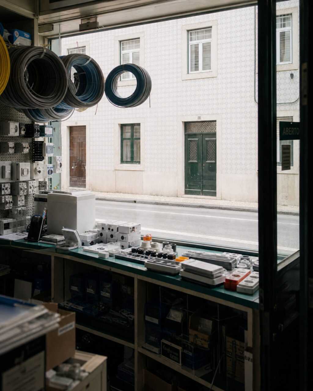 Interior view of an electrical shop looking onto a tiled Lisbon street