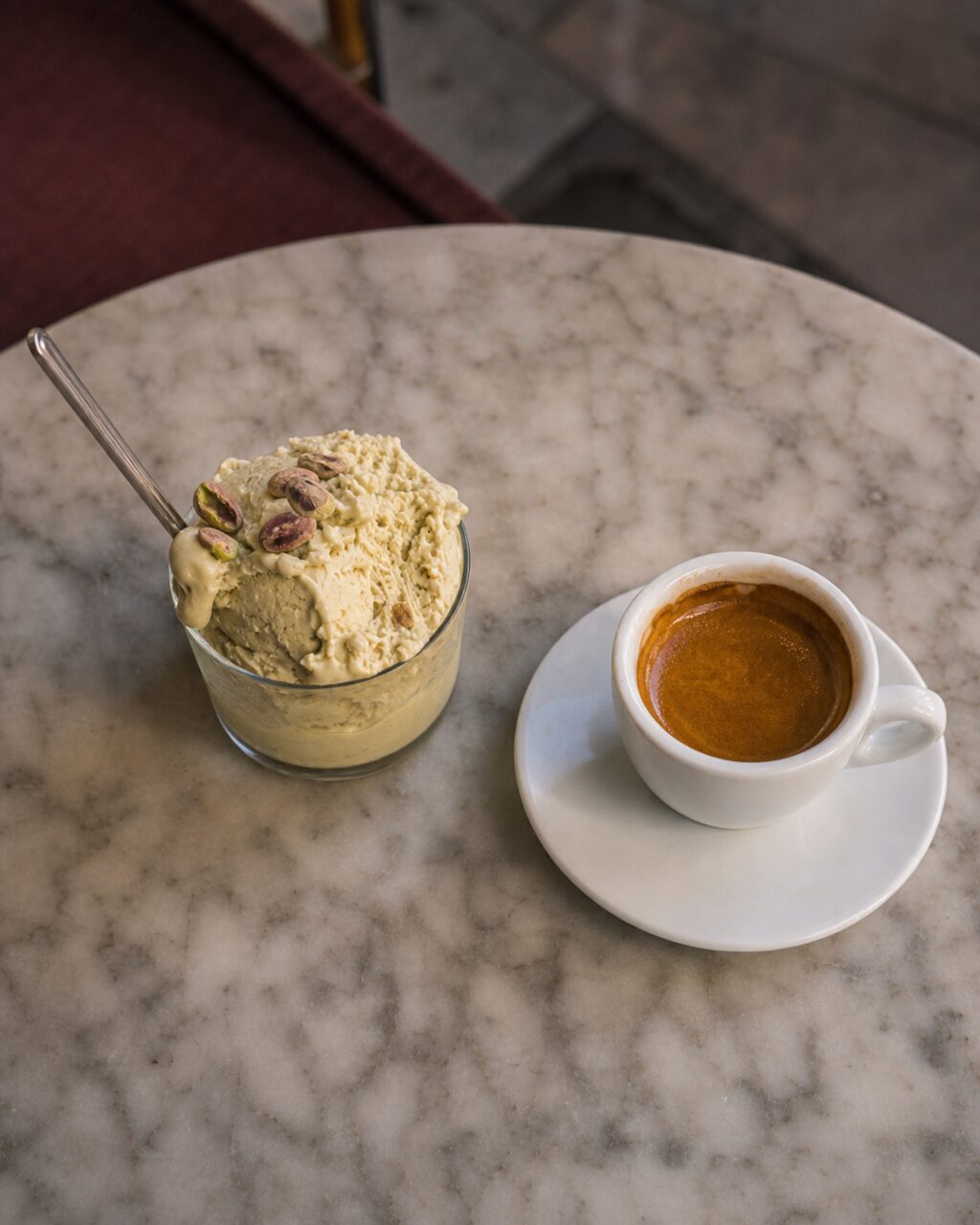 Overhead view of pistachio-topped dessert and coffee cup