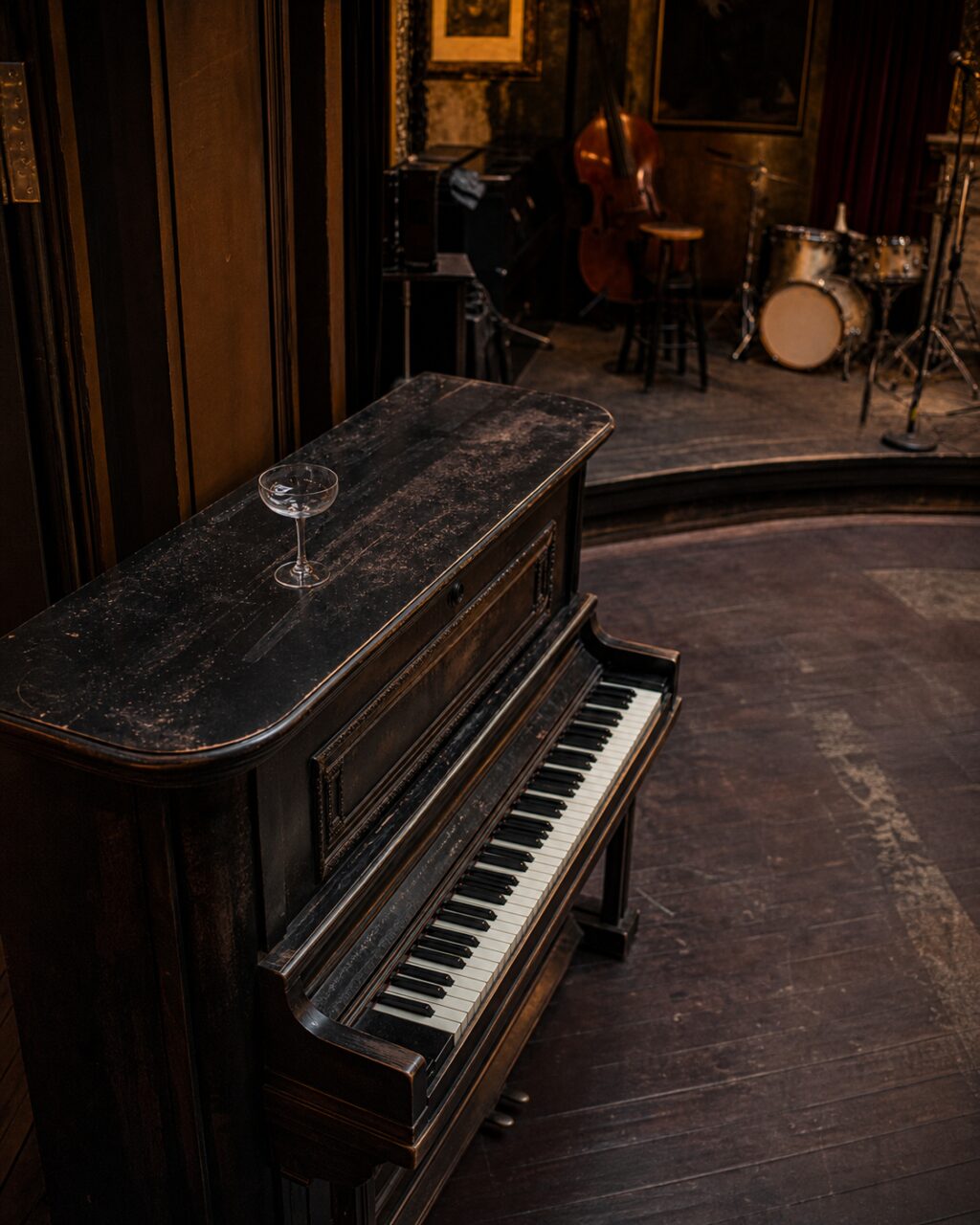 Aufsicht auf ein schwarzes Klavier und Glas mit Blick zur Musikbühne