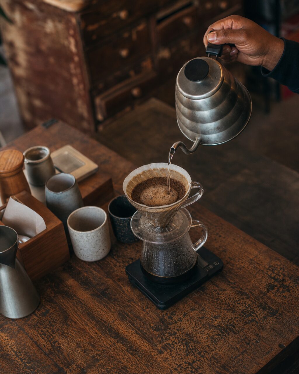 Draufsicht auf Filterkaffee mit Kessel, Dripper und Glaskaraffe
