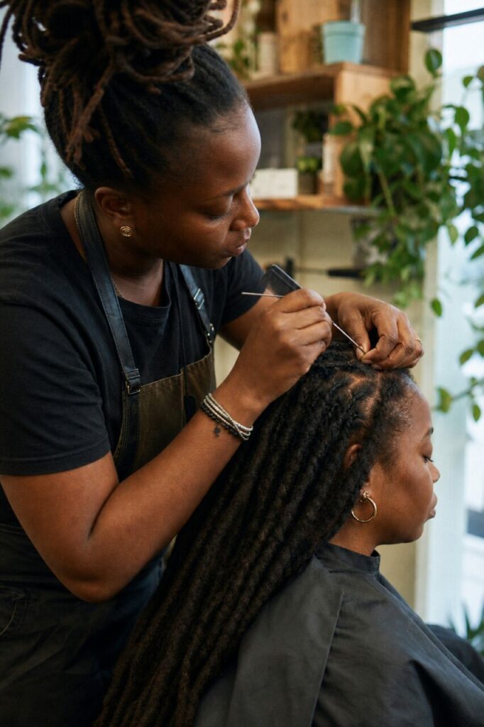 Une loc rejoint la couronne sous les mains de la coiffeuse